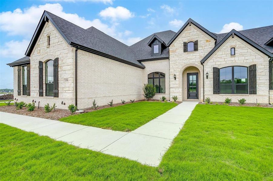 French country inspired facade featuring a front yard