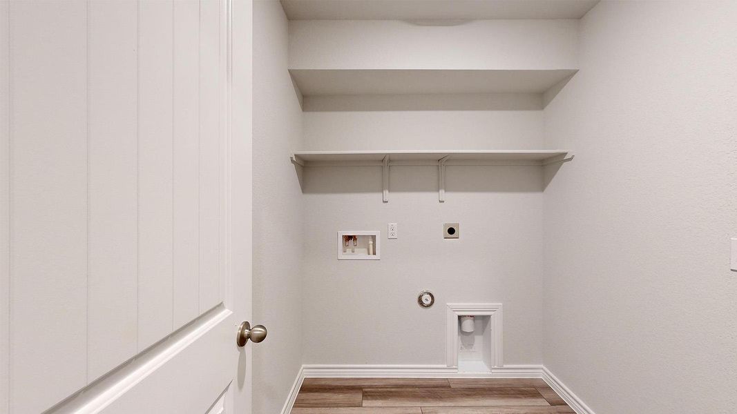 Laundry area featuring washer hookup, gas dryer hookup, hookup for an electric dryer, and light wood-style floors Laundry area featuring washer hookup, gas dryer hookup, hookup for an electric dryer, and light wood-style floors