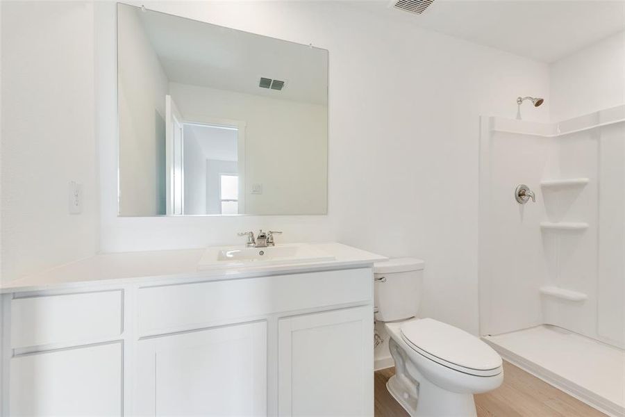 Full bathroom with vanity, wood finished floors, and a shower Full bathroom with vanity, wood finished floors, and a shower