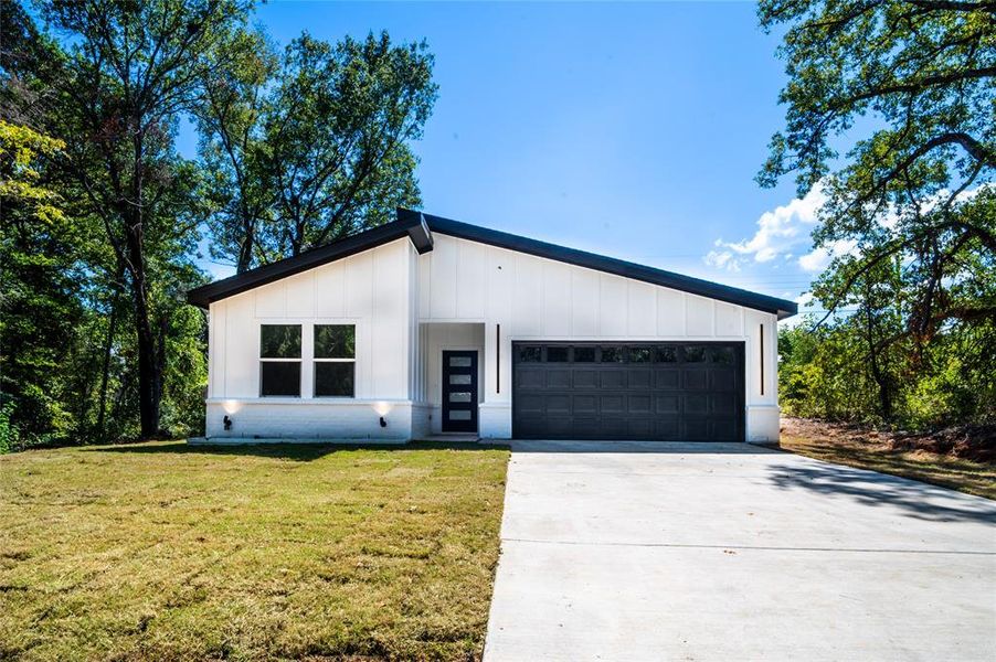 View of front facade with a front lawn and a garage