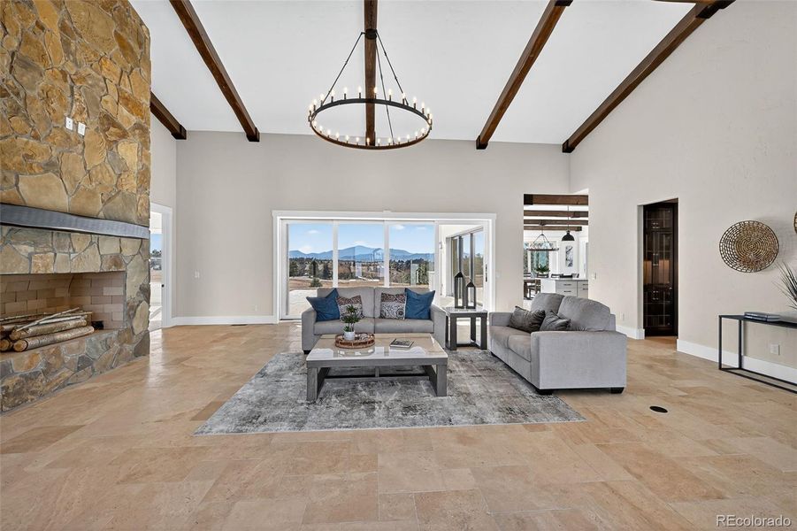 Great Room with wood burning fireplace. Retractable window walls in background.