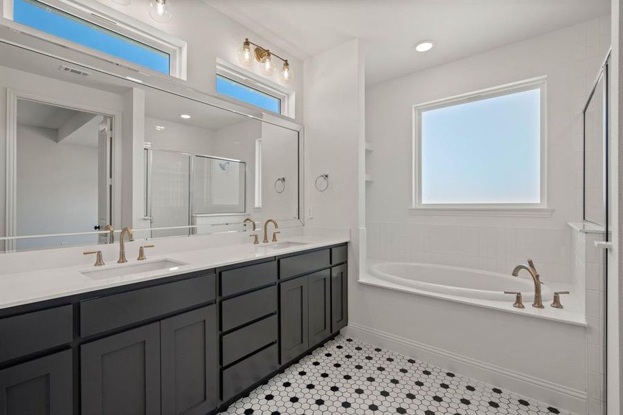 Bathroom with a healthy amount of sunlight, a stall shower, visible vents, and a sink