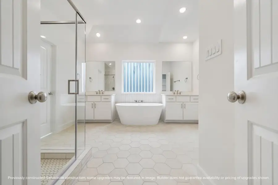 A bright, beautifully balanced bath with separate vanities, soaking tub, and oversized shower — function meets comfort.