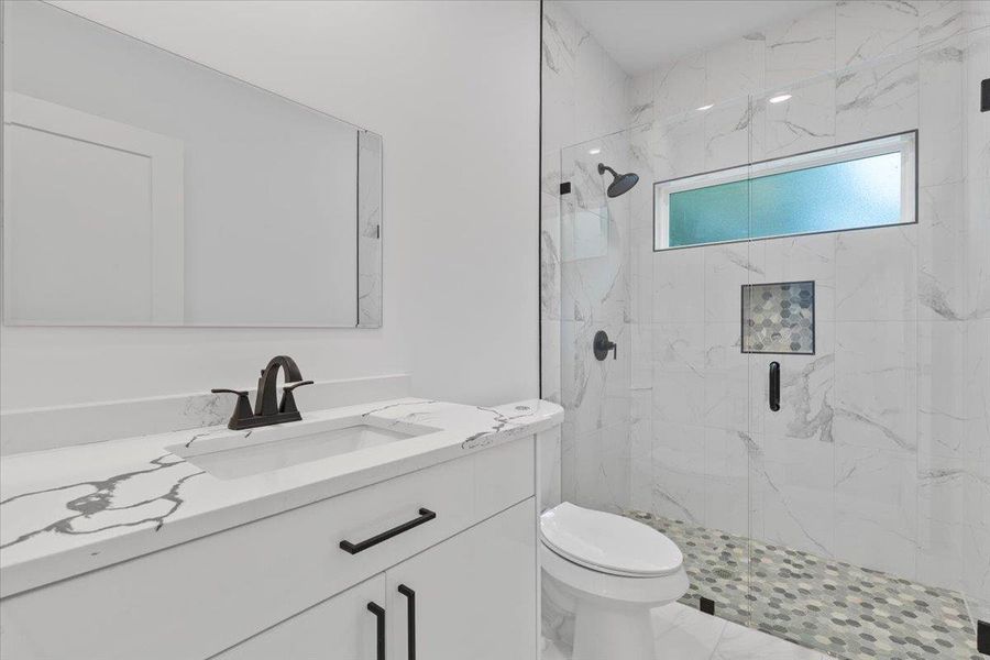 2nd Full bathroom featuring a marble finish Floor to ceiling shower 2nd Full bathroom featuring a marble finish Floor to ceiling shower