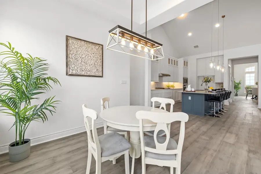 Dining room with light wood-style flooring, a chandelier, high vaulted ceiling, and recessed lighting