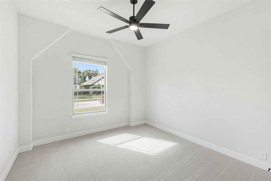 Empty bedroom with vaulted ceiling, black ceiling fan, carpet flooring, and single window