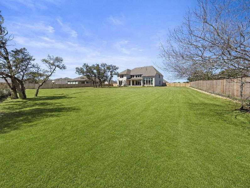 An expansive green lawn provides ample space for outdoor activities, leading to a generously proportioned residence. An expansive green lawn provides ample space for outdoor activities, leading to a generously proportioned residence.