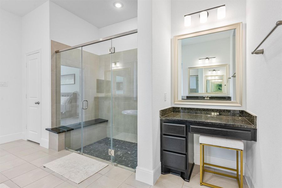 Primary bath boasts separate vanity sinks a nice sized garden tub, a make up vanity, large standing shower with bench, and wonderful natural light.