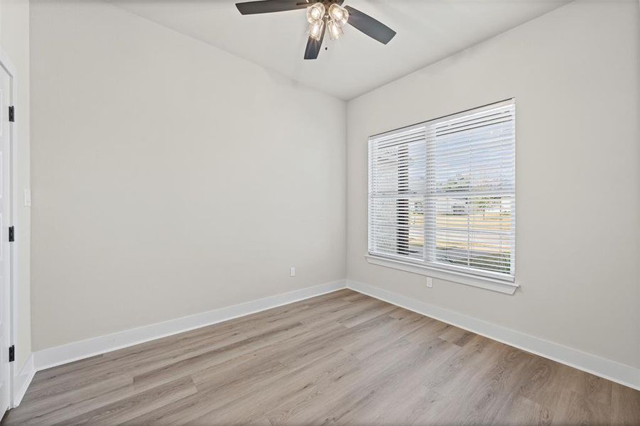 Empty room with light wood finished floors and ceiling fan