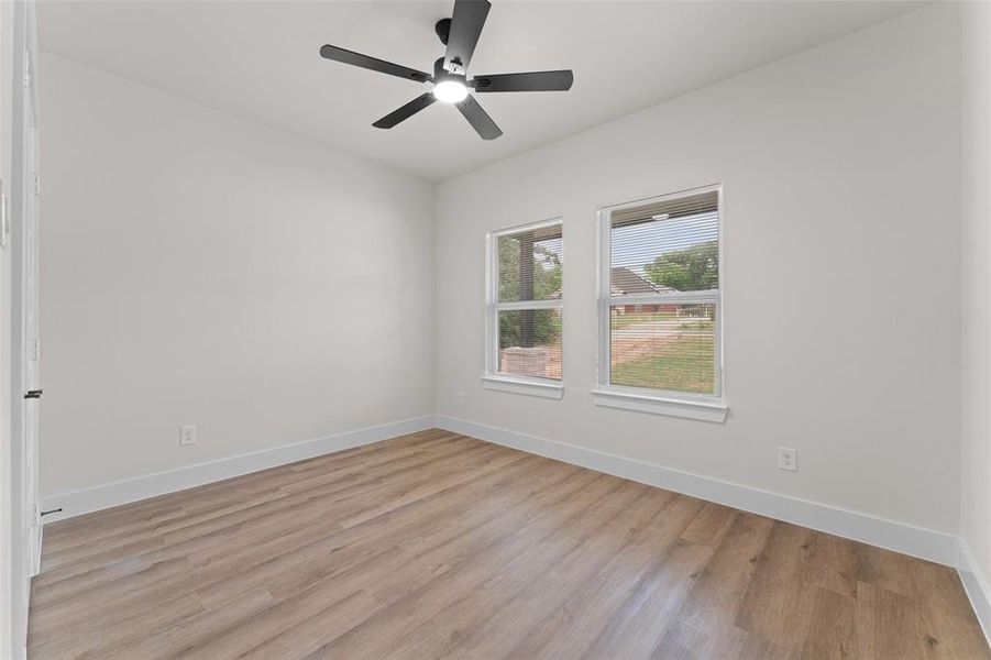 Unfurnished room featuring light wood-style flooring, a ceiling fan, and baseboards Unfurnished room featuring light wood-style flooring, a ceiling fan, and baseboards