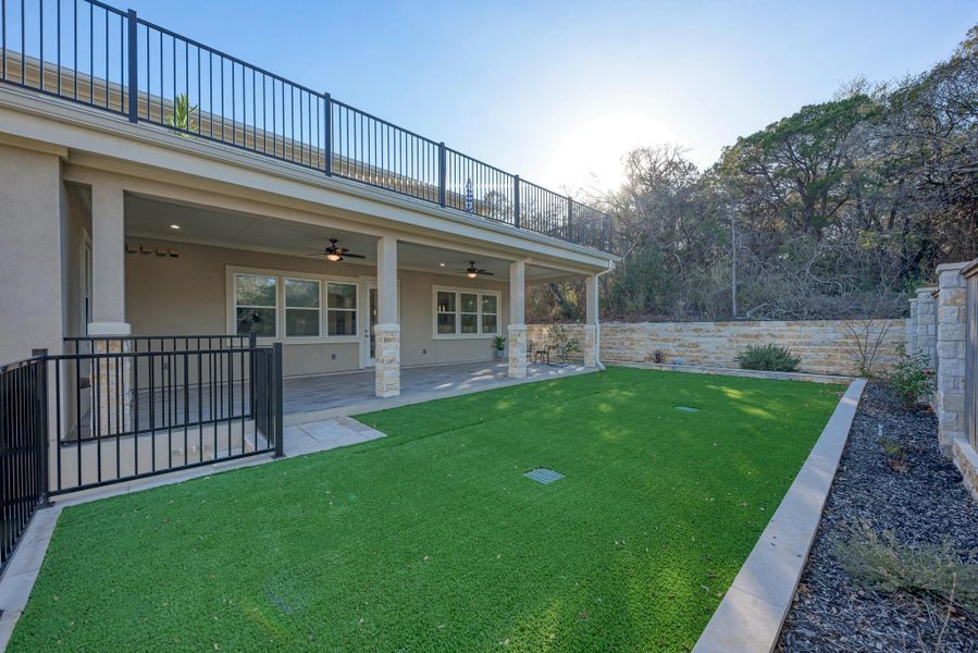Fenced backyard with a ceiling fan and a patio