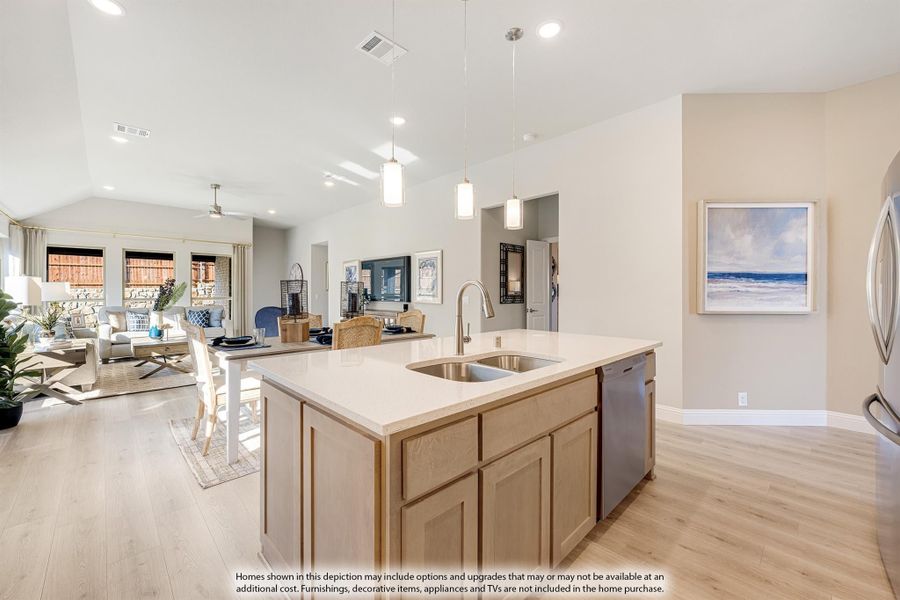 Kitchen island with sink and light wood cabinets, open to dining and living areas with vaulted ceiling and hardwood floors Kitchen island with sink and light wood cabinets, open to dining and living areas with vaulted ceiling and hardwood floors