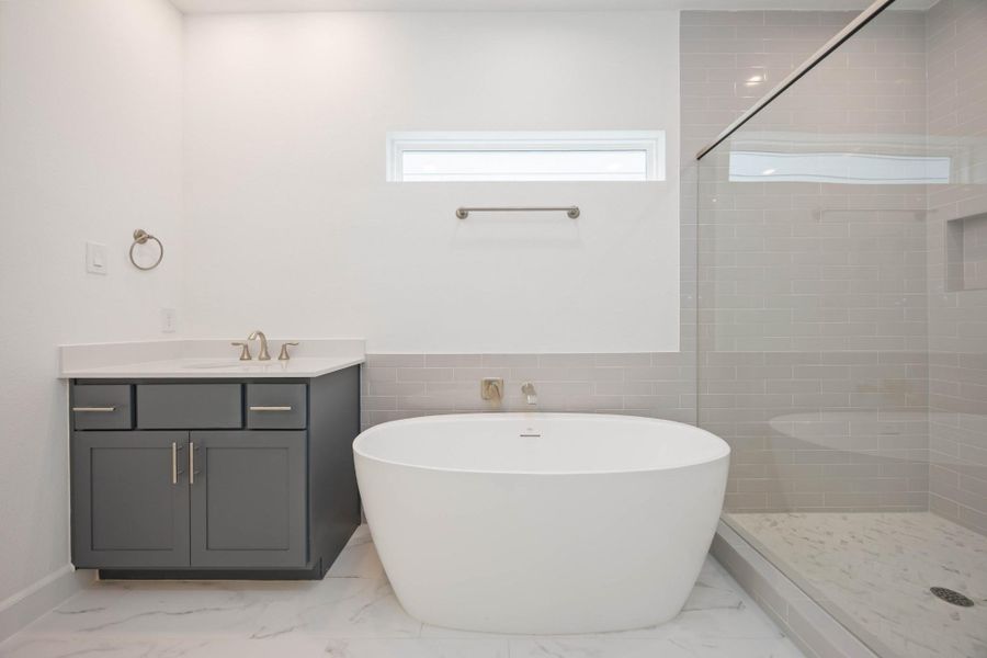 Hello, wow factor. The combination of polished tile, soft gray cabinetry, and natural light makes this bathroom feel both calming and elevated.