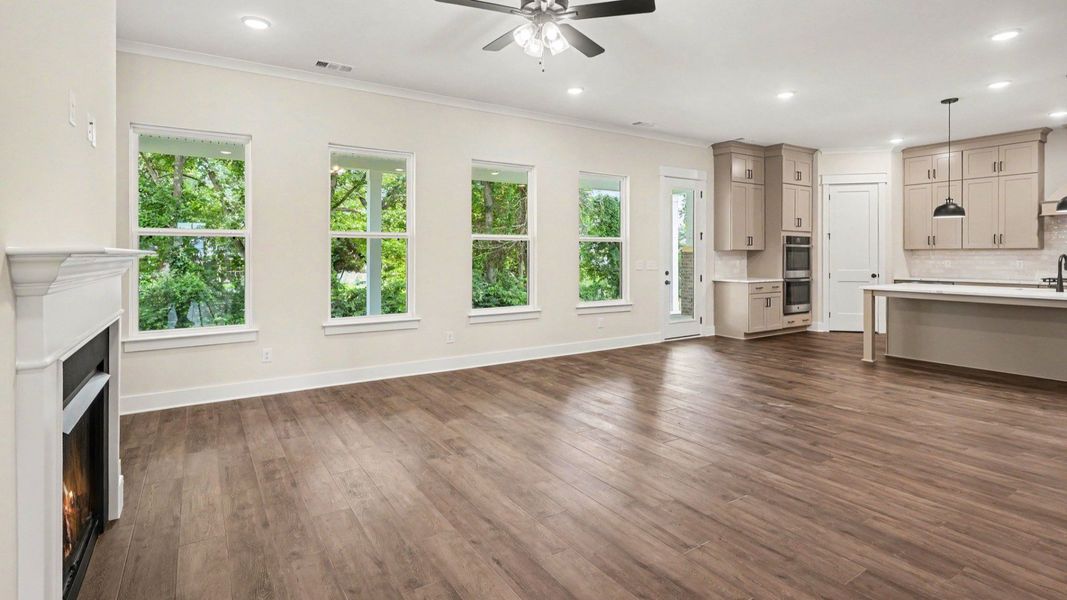 Gathering room with fireplace, ceiling fan, and hard surface flooring Gathering room with fireplace, ceiling fan, and hard surface flooring
