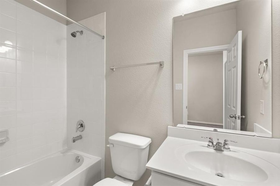 The secondary bath features tile flooring, white cabinetry and light countertops and a shower/tub combo. Perfect for accommodating any visiting family and friends.