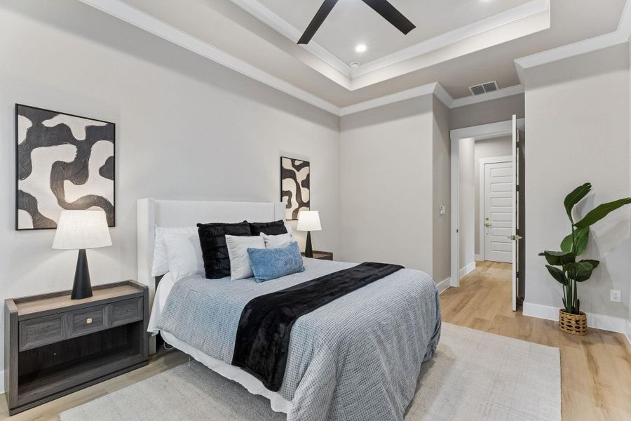 A restful bedroom offers a coffered ceiling and sleek hardwood flooring, perfect for serene living.