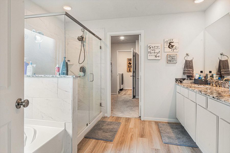Enter the primary ensuite bath with separate bath and shower and double sinks with plenty of counter space. Walk through the bathroom to the oversized walk-in closet and through to the utility room access upgrade! Enter the primary ensuite bath with separate bath and shower and double sinks with plenty of counter space. Walk through the bathroom to the oversized walk-in closet and through to the utility room access upgrade!