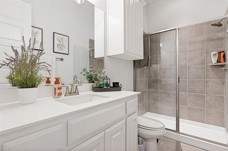 Bathroom featuring a single vanity with a white countertop, an integrated sink, and white cabinetry