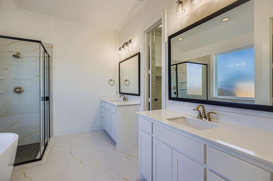 Bathroom featuring marble look tile flooring, a shower stall, two vanities, a freestanding bath, and recessed lighting