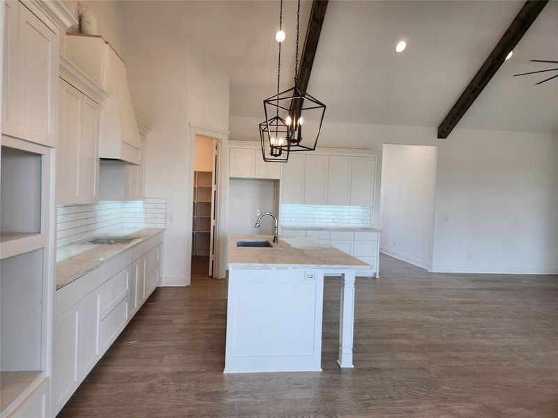 Kitchen featuring backsplash, dark hardwood / wood-style flooring, and beamed ceiling