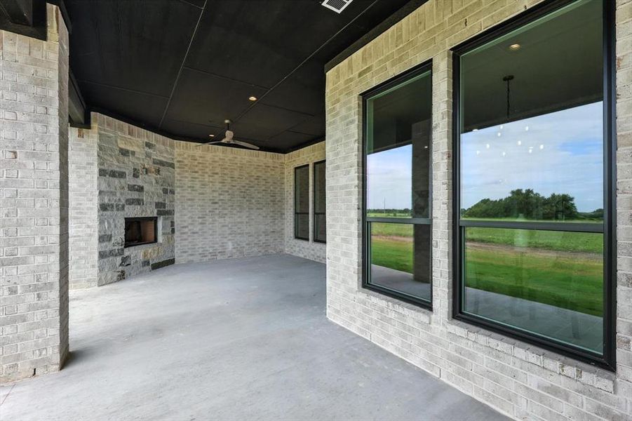 View of patio with a large fireplace and a ceiling fan View of patio with a large fireplace and a ceiling fan