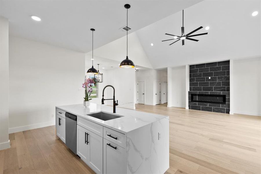 Kitchen with a sink, open floor plan, stainless steel dishwasher, pendant lighting, and recessed lighting Kitchen with a sink, open floor plan, stainless steel dishwasher, pendant lighting, and recessed lighting
