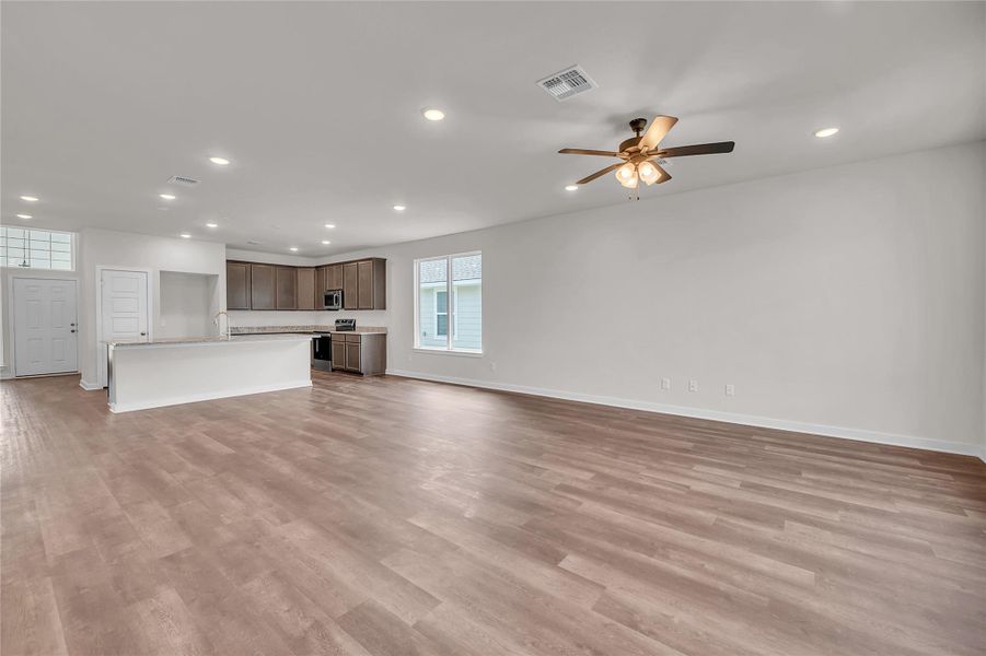 Unfurnished living room with recessed lighting, light wood finished floors, and ceiling fan Unfurnished living room with recessed lighting, light wood finished floors, and ceiling fan