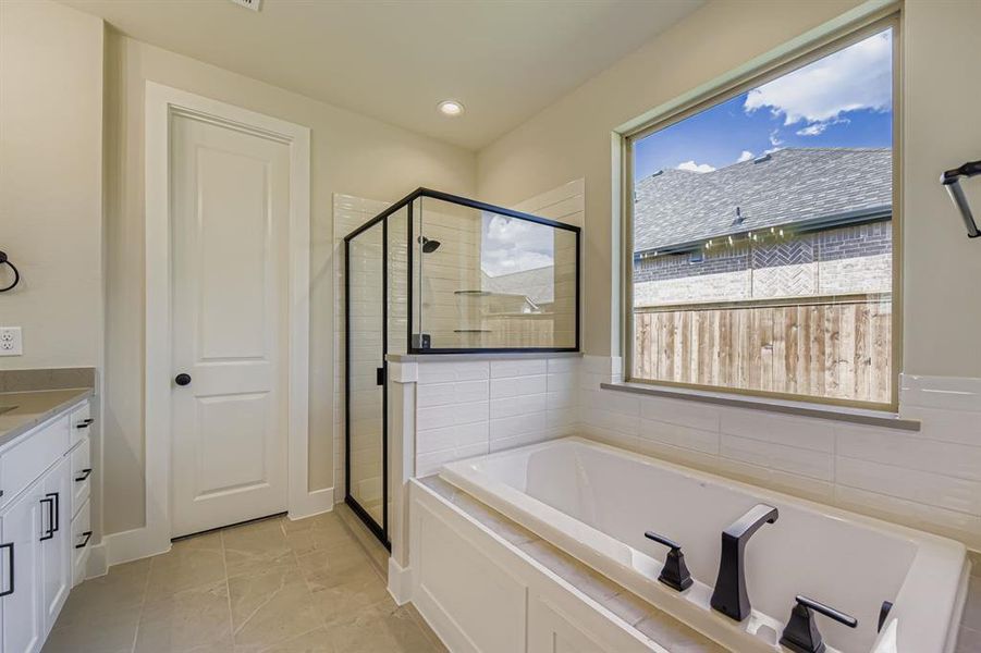 Full bathroom with a shower stall, vanity, a bath, light tile patterned floors, and recessed lighting