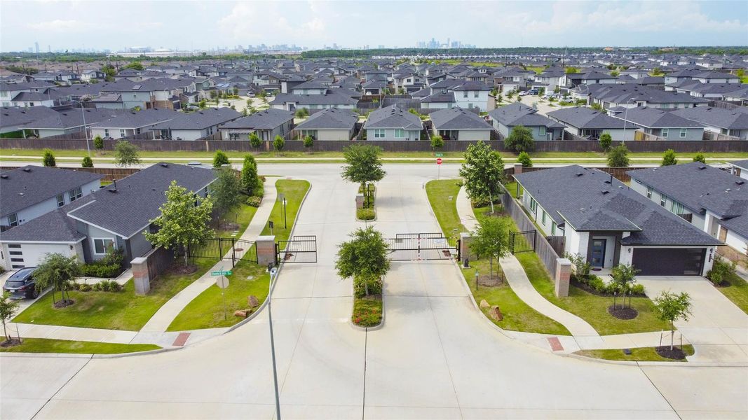 An impressive aerial view showcases the gated entry of this secure community, with the Houston skyline just beyond. Clean streets, uniform landscaping, and well-maintained homes set a tone of pride and privacy for residents who enjoy easy access to the city while living in a quiet, suburban enclave. An impressive aerial view showcases the gated entry of this secure community, with the Houston skyline just beyond. Clean streets, uniform landscaping, and well-maintained homes set a tone of pride and privacy for residents who enjoy easy access to the city while living in a quiet, suburban enclave.