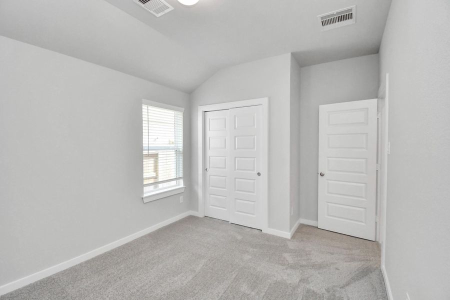 Generously sized secondary bedrooms featuring spacious closets, soft and inviting carpeting underfoot, large windows allowing plenty of natural light, and the added touch of privacy blinds for your personal retreat.