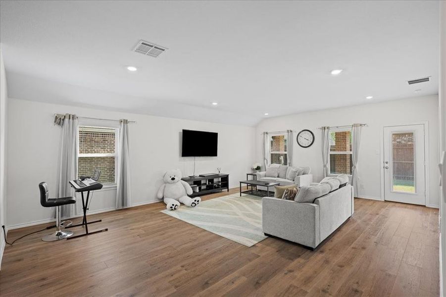 Living area with wood finished floors and recessed lighting Living area with wood finished floors and recessed lighting