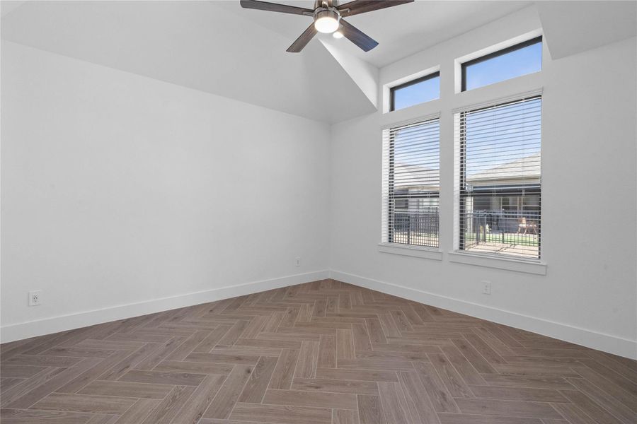 Relax and unwind after a long day in this impressive primary suite! This generously sized room offers gorgeous tile flooring, neutral-toned paint, high sloped ceilings with a ceiling fan, and large windows for added comfort and tranquility. Relax and unwind after a long day in this impressive primary suite! This generously sized room offers gorgeous tile flooring, neutral-toned paint, high sloped ceilings with a ceiling fan, and large windows for added comfort and tranquility.