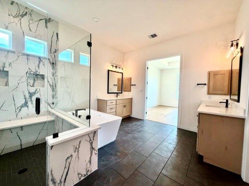 Luxurious spa-like bath features a generous walk-in shower and elegant freestanding tub. Luxurious spa-like bath features a generous walk-in shower and elegant freestanding tub.