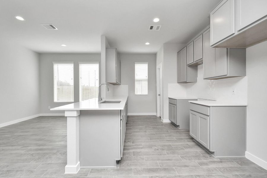 Culinary haven, featuring granite countertops, a tile backsplash, stainless steel appliances (to be installed), and 42” upper cabinets. Sample photo of completed home with similar floor plan. Actual colors and selections may vary.