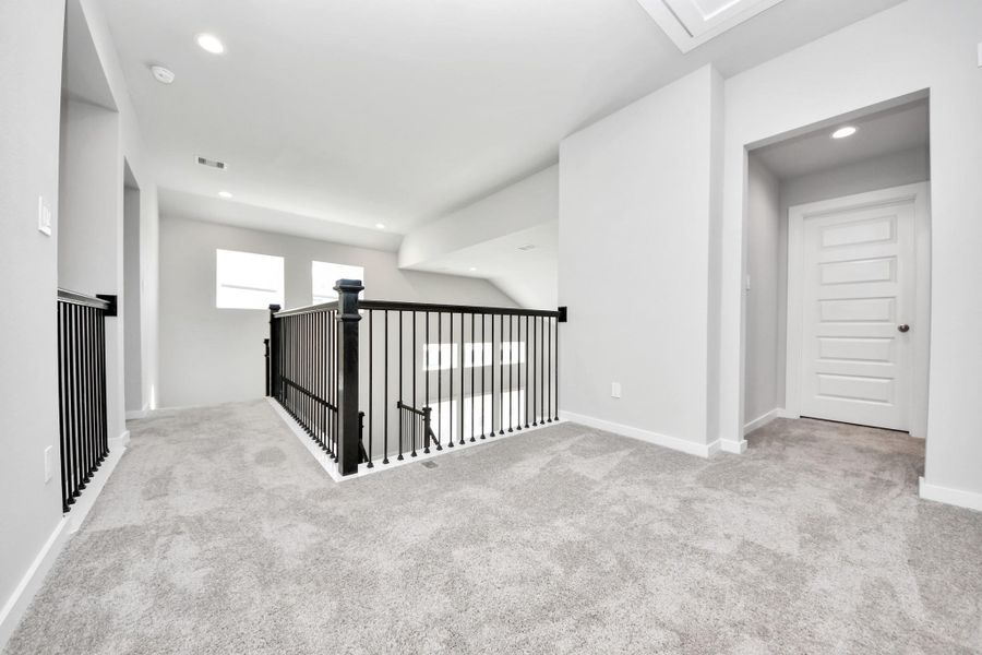 Ascend to relaxation in this fantastic game room! Ideal for both casual gatherings and adult gaming, it boasts plush carpet, lofty ceilings, custom paint, and ample windows for abundant natural light. Sample photo of completed home with similar floor plan. Actual colors and selections may vary.