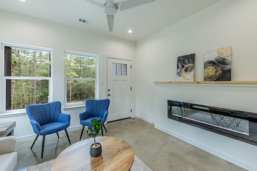 Open-concept living area featuring a modern linear fireplace, a ceiling fan, and recessed lighting Open-concept living area featuring a modern linear fireplace, a ceiling fan, and recessed lighting