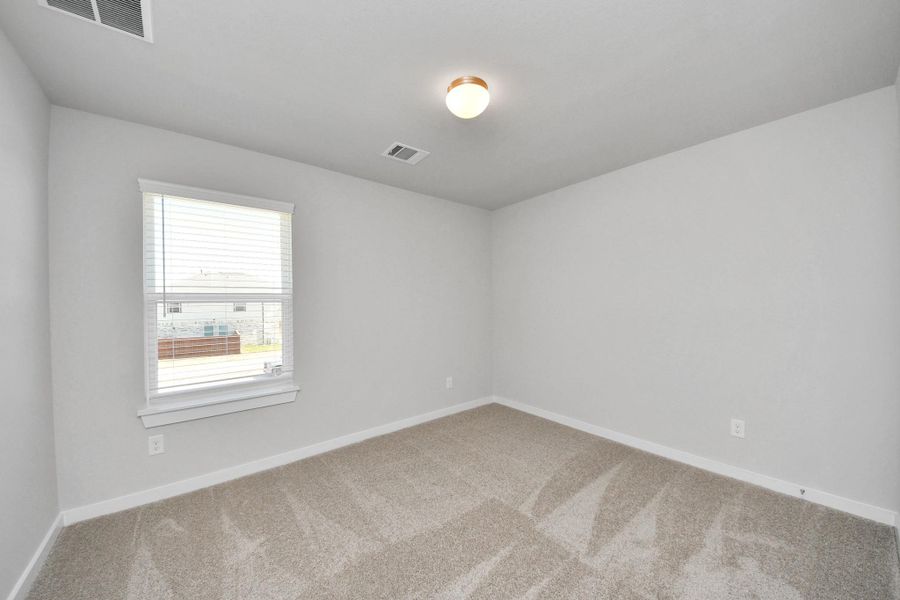 Secondary bedroom features plush carpeting, large windows that let in plenty of natural light, bright paint, and spacious closets. Sample photo of completed home with similar floor plan. Actual colors and selections may vary. Secondary bedroom features plush carpeting, large windows that let in plenty of natural light, bright paint, and spacious closets. Sample photo of completed home with similar floor plan. Actual colors and selections may vary.