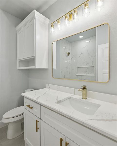 Bathroom with vanity, toilet, and a tile shower