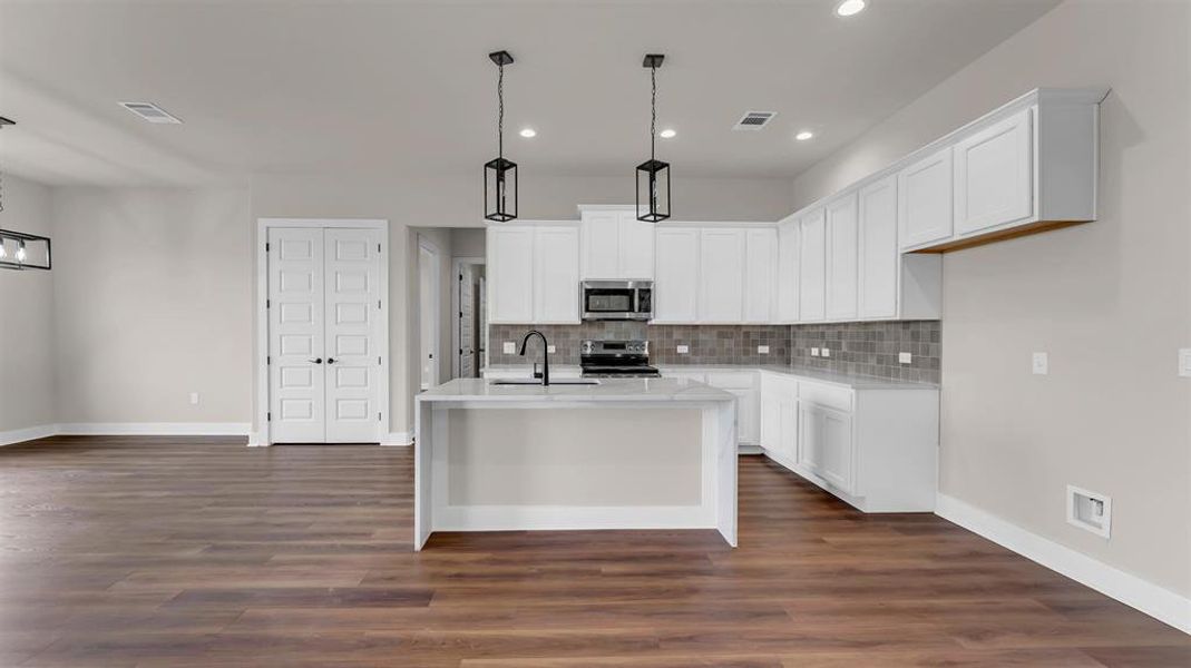 Rich wood floors anchor this modern cooking space lined with crisp white cabinetry. Rich wood floors anchor this modern cooking space lined with crisp white cabinetry.