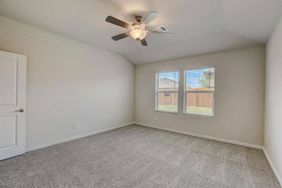 Unfurnished room featuring light colored carpet, lofted ceiling, and ceiling fan