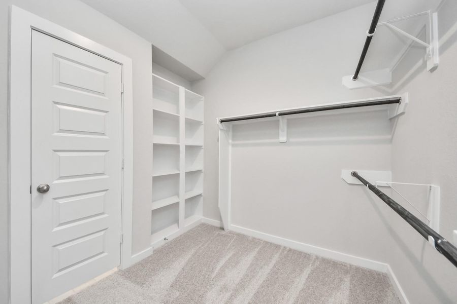 Walk-in closet that epitomizes luxury and practicality. This generously sized space features built-in shelving, offering abundant room for impeccable organization. High ceilings and recessed lighting create a bright and welcoming ambiance. Sample photo of completed home with similar floor plan. Actual colors and selections may vary. Walk-in closet that epitomizes luxury and practicality. This generously sized space features built-in shelving, offering abundant room for impeccable organization. High ceilings and recessed lighting create a bright and welcoming ambiance. Sample photo of completed home with similar floor plan. Actual colors and selections may vary.
