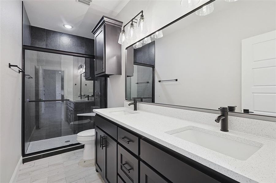 Bathroom featuring hardwood / wood-style flooring, vanity, toilet, and a shower with door