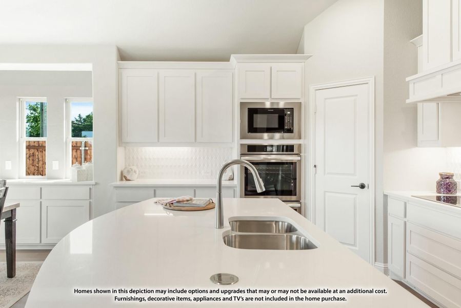 Kitchen with white cabinets, stainless steel appliances, and large island with undermount sink