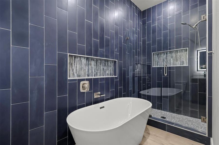 Bathroom with tile walls and independent shower and bath