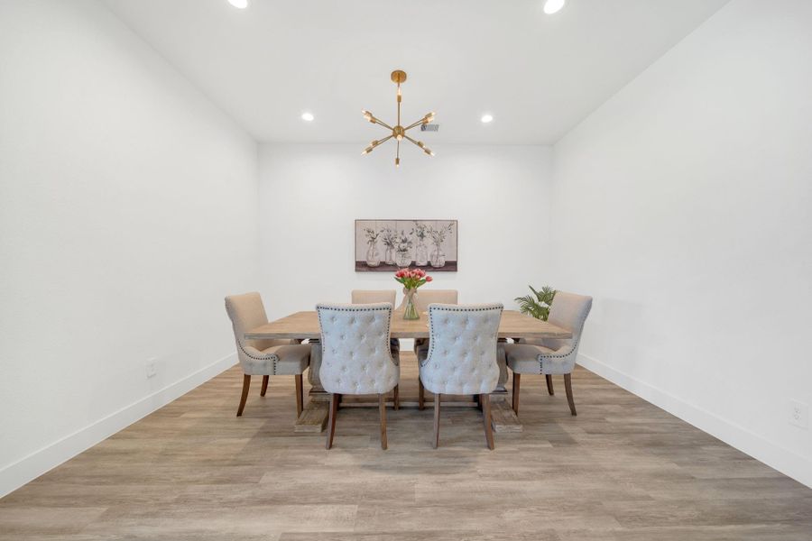 This spacious  dining room opens up to the main living area and feautures a modern light fixture.