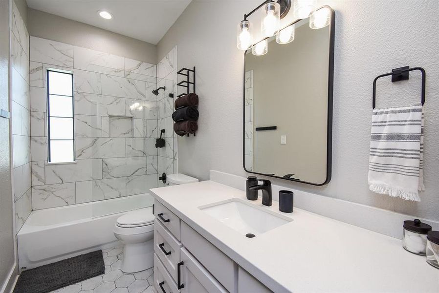 Full-size bathroom with tub-shower combo, located between both bedrooms