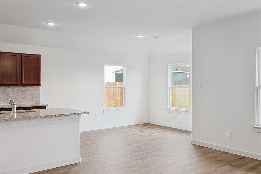 Unfurnished living room featuring light hardwood / wood-style flooring and sink