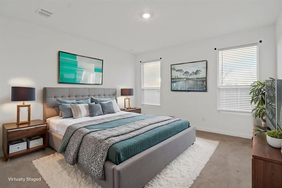 Bedroom with light carpet and multiple windows