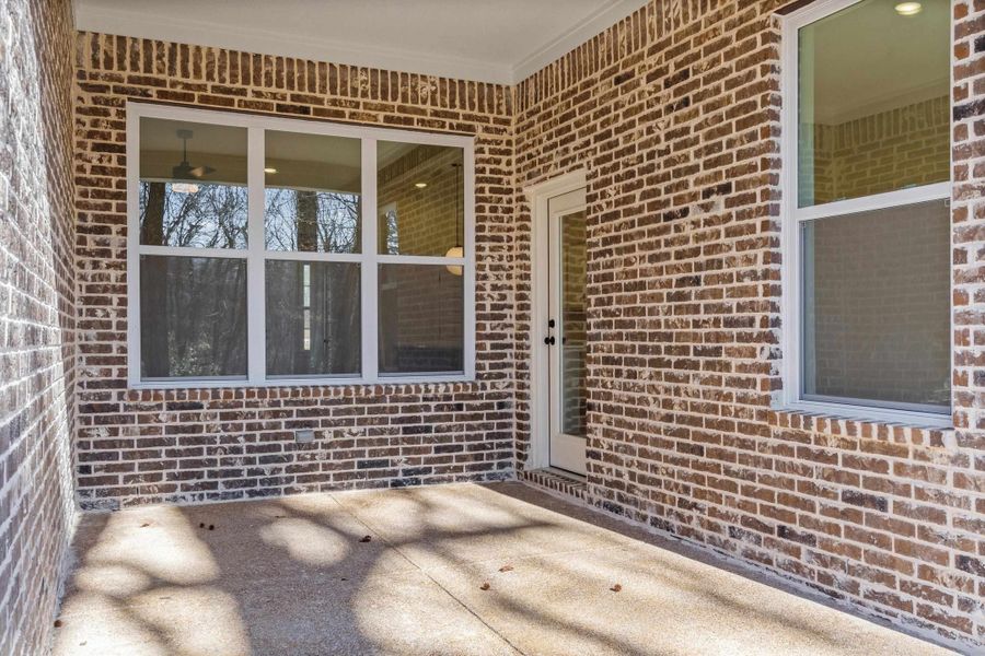 Doorway to property with brick siding and a patio Doorway to property with brick siding and a patio