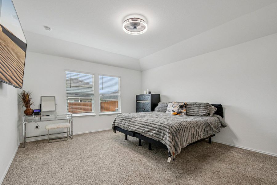Bedroom with light colored carpet and vaulted ceiling